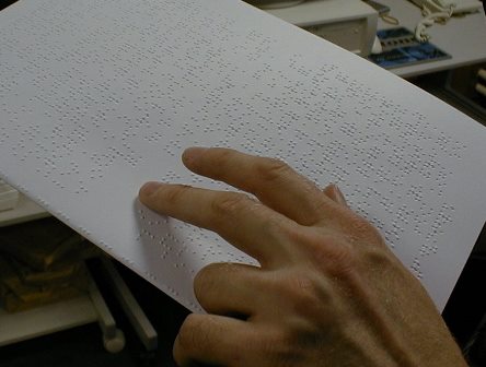 a-close-up-of-a-persons-hand-reading-braille